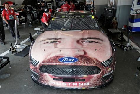 NASCAR's Corey LaJoie has his face painted on his race car's hood