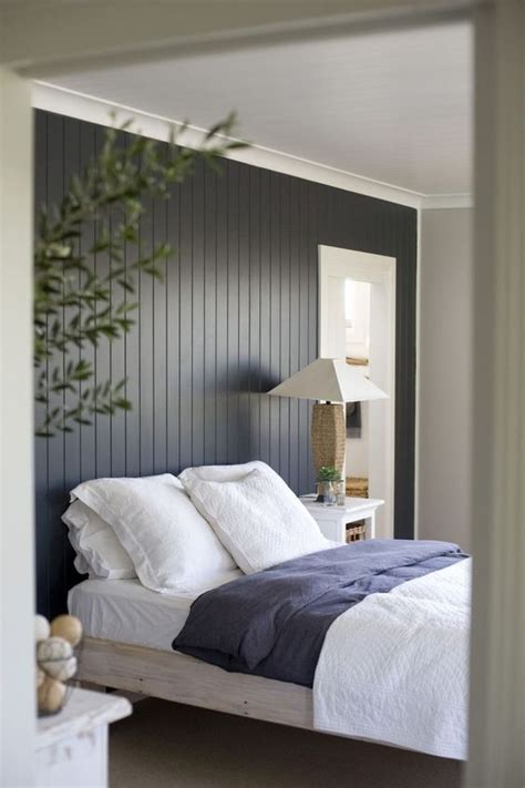 The dark painted wood paneling feature wall makes quite a statement in this simple yet ...