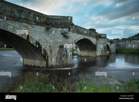 Scenic view of bridge spanning River Wharfe flowing gently through Burnsall village, on summer ...