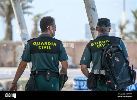 Two Spanish Civil Guard (Guardia Civil) Officers patrol the harbour on the Spanish island of ...