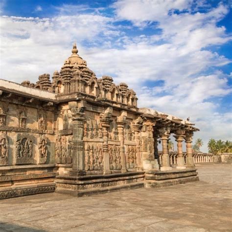 an old stone building with statues on the side and blue sky in the back ground