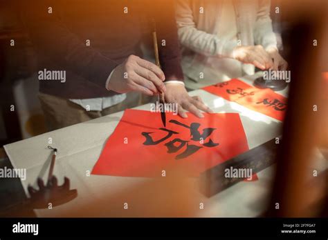 Senior couple writing calligraphy on couplets Stock Photo - Alamy