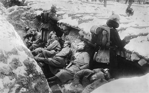 German soldiers sleeping in snowy trenches as two guards stand with ...