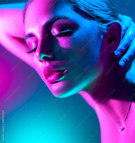 Fashion model woman in colorful bright neon lights posing in studio. Portrait of beautiful girl ...