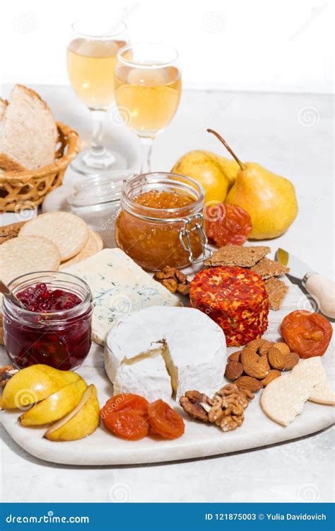 Assortment of Gourmet Cheeses and Snacks, Glass of White Wine Stock ...