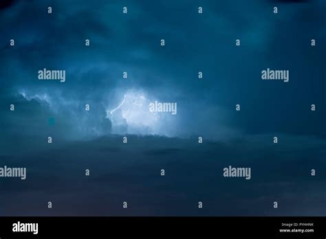 Blue Lightning strike surrounded by storm clouds Stock Photo - Alamy