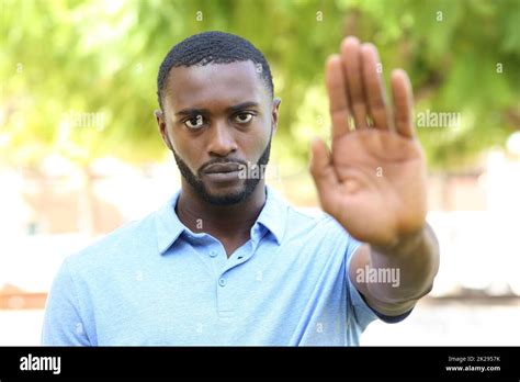 Black man gesturing stop sign in a park Stock Photo - Alamy