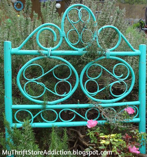 a blue metal bed frame surrounded by plants