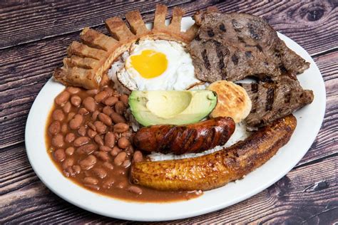 a white plate topped with meat, beans and an egg