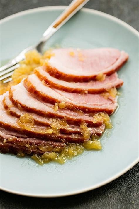 Pineapple Glazed Ham slices served on a plate with a fork and extra glazed drizzled over the top ...