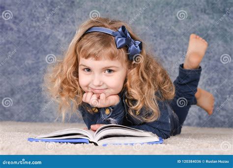 Cute Little Girl Reading Book while Lying on Floor Stock Photo - Image ...