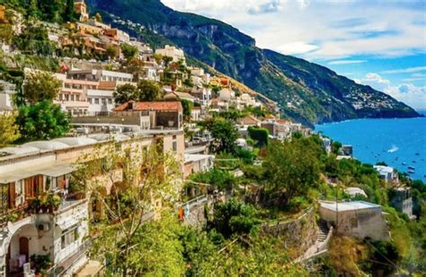 an old town on the side of a cliff by the ocean