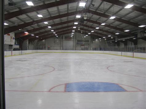 an indoor hockey rink with lights on the ceiling