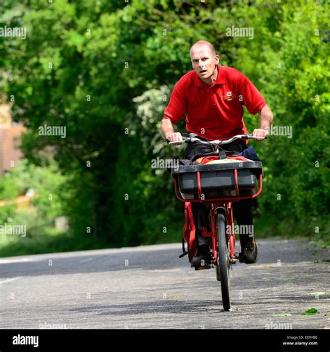 Royal Mail postman on a bicycle with a basket and side pannier Stock ...