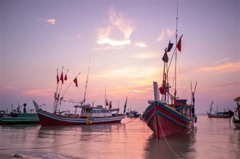 Premium Photo | Fishing boats in harbor at sunset