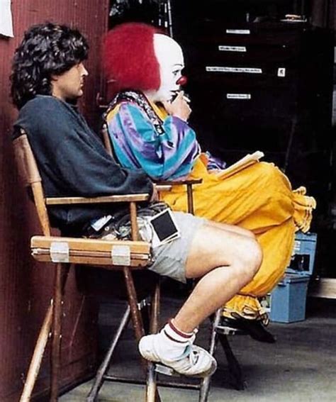 two people sitting in chairs with clown makeup on their faces and one person wearing a wig