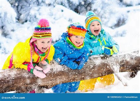 Kids Playing in Snow. Children Play Outdoors in Winter Snowfall. Stock Photo - Image of park ...