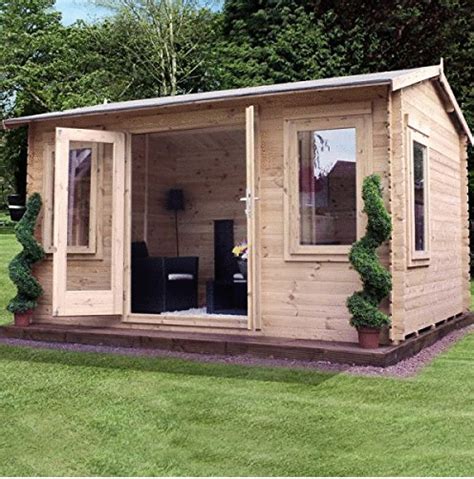 a small wooden shed with its doors open on the grass in front of some trees