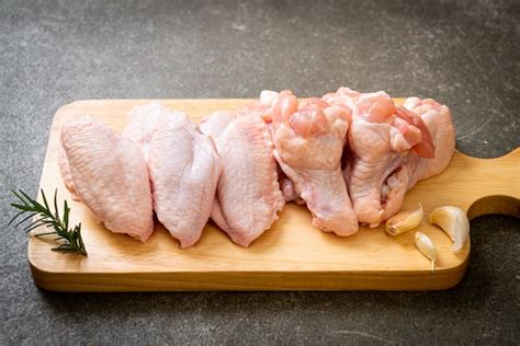 Premium Photo | Fresh raw chicken wings on wooden board