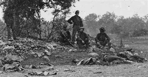 Union soldiers posing with dead Confederate troops who died during the Battle of Antietam at the ...