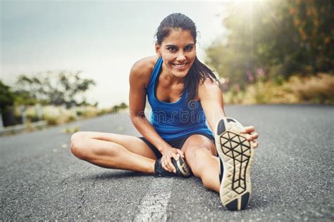 Stretch before You Start Running. a Young Beautiful Woman Training for ...