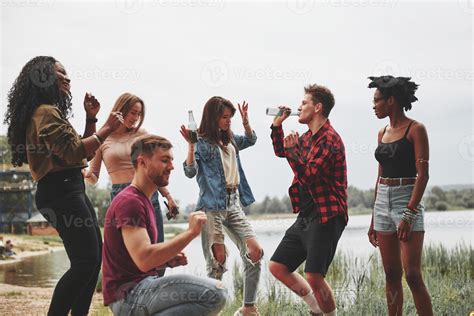 Let's dance. Group of people have picnic on the beach. Friends have fun ...