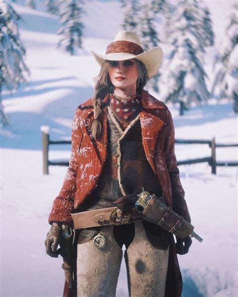 a woman wearing a cowboy hat standing in the snow with her hands on her hips