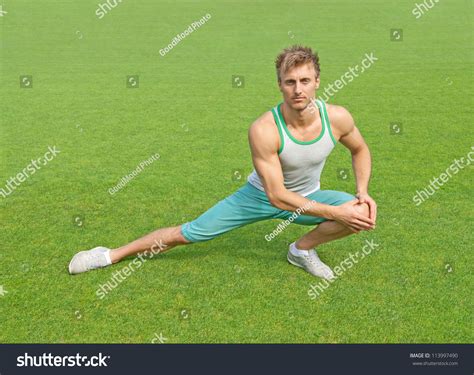 Fit Young Man Exercising Outdoors On Green Field. Stock Photo 113997490 ...