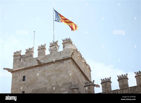 Medieval town gate of Valencia and Spanish flag from below Stock Photo ...