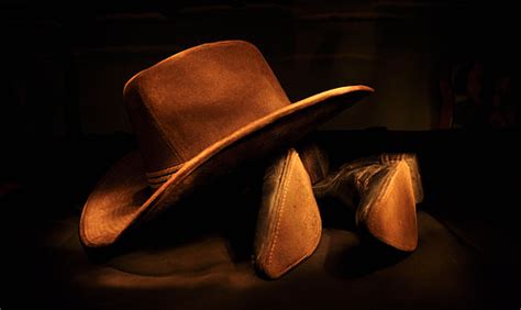 Royalty-Free photo: Brown cowboy hat on black boots | PickPik