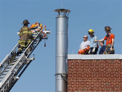 Firefighters use ladder truck for rescue from school roof