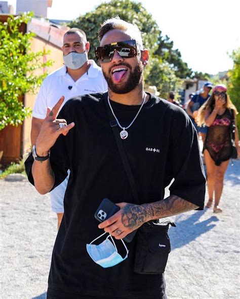 a man in sunglasses and a face mask making the peace sign with his hand ...