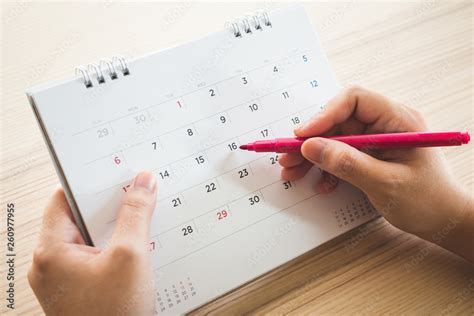 Hand with pen writing on calendar page closeup Stock Photo | Adobe Stock