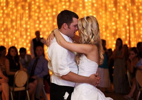 Image by MedeyaPhotography. Romantic couple dancing in front of the wall of lights duri ...