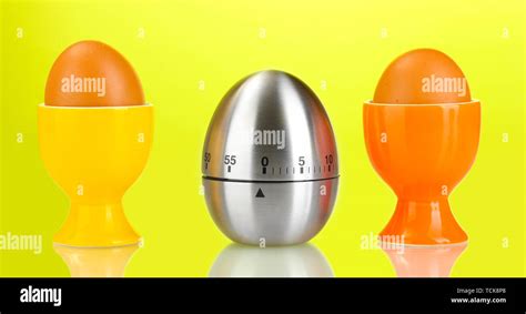 egg timer and egg in color stand on green background Stock Photo - Alamy