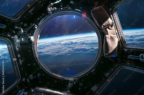 Earth planet in ISS porthole. View from Cupola. International space station. Orbit and ...