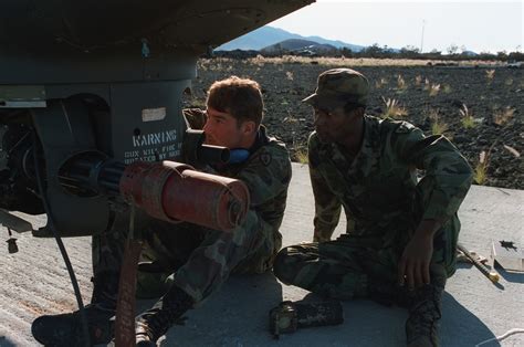Ground crewmen of F Company, 25th Combat Aviation Battalion, examine a grenade launcher mounted ...