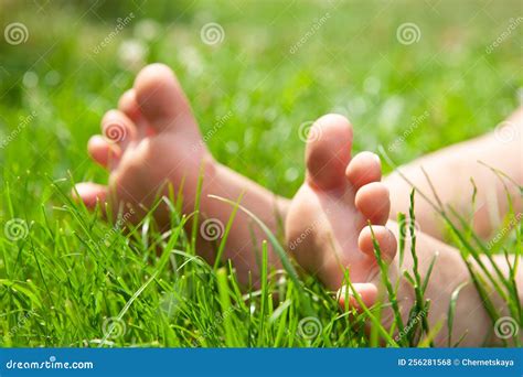 Child Sitting Barefoot on Green Grass Outdoors, Closeup Stock Photo ...