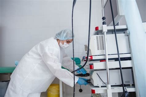 Premium Photo | A young female endoscopist in a white protective suit cap and gloves prepares ...