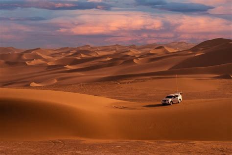 A Car on a Desert at Sunset · Free Stock Photo