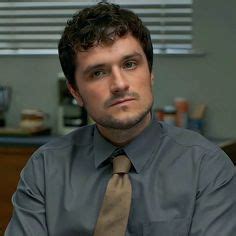 a man wearing a shirt and tie sitting in an office chair with his arms crossed