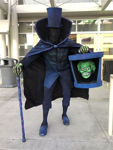 a man dressed up in a costume and holding a box with a creepy face on it