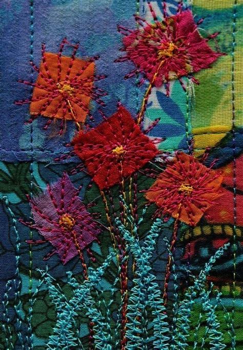 some very pretty flowers on a patchwork piece of fabric with stitching ...