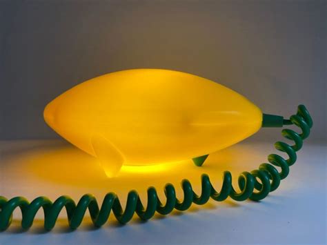a yellow object with green spirals on the bottom and sides, sitting on ...