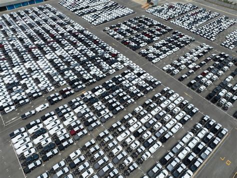 Premium Photo | Aerial view of new cars stock at factory parking lot ...