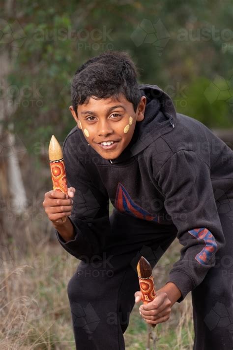 Image of Young Aboriginal Boy with clapstick instrument - Austockphoto