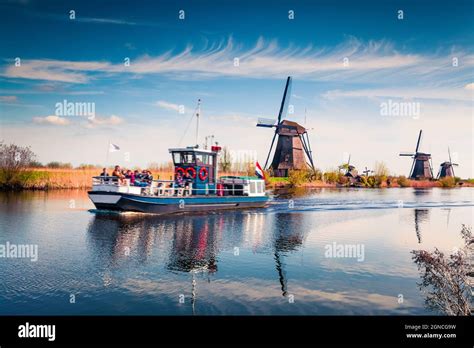 Famous windmills in Kinderdijk museum in Holland. Sunny spring morning in countryside. Colorful ...