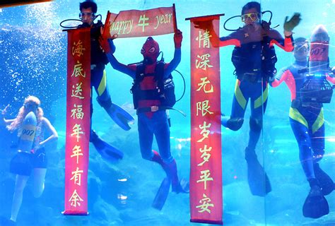 Divers from Qingdao Underwater World performed in Qingdao, China, Thursday, wishing people good ...
