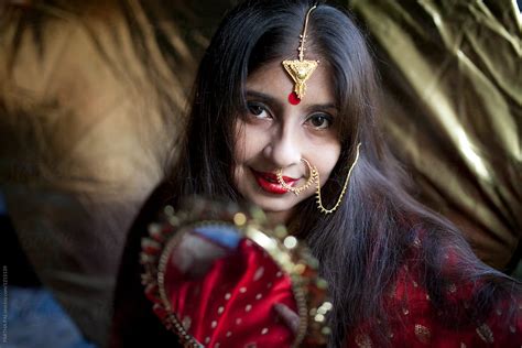 «Young Indian Woman With Decorative Jewellery And Golden Mirror» del colaborador de Stocksy ...