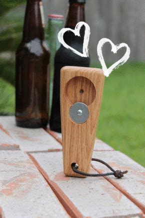 a wooden speaker sitting on top of a table next to two beer bottles and a bottle opener